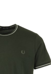 T-shirt verde scuro a maniche corte con colletto e polsini a strisce, caratterizzato da un piccolo logo ricamato a forma di alloro sul petto.