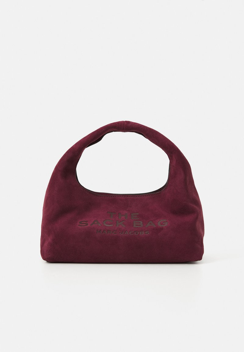 Pequena bolsa de camurça burgundy com alça curva, "THE SACK BAG MARC JACOBS" gravado na frente, contra um fundo branco.