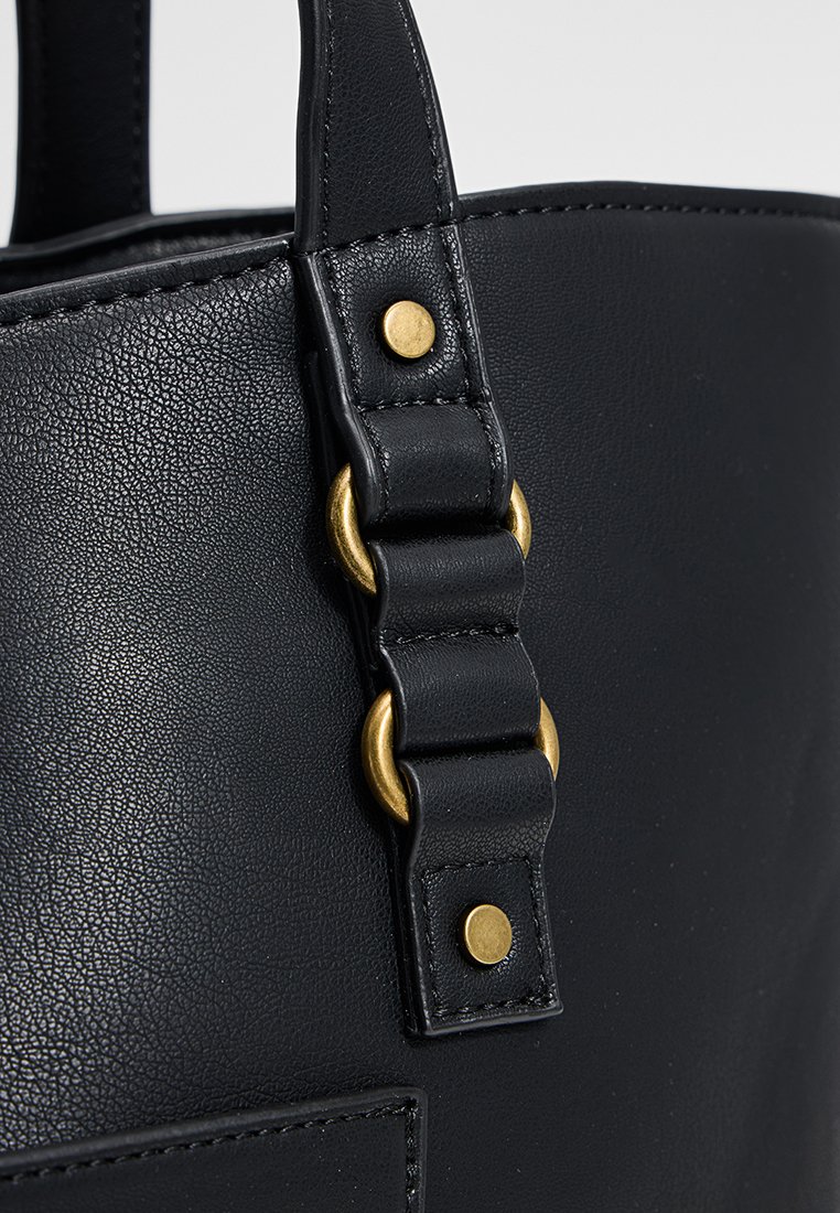 Bolso de mano de cuero negro con acabado texturizado, forma estructurada y detalles en hardware dorado en la correa.