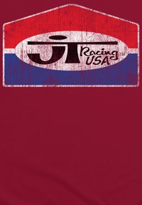 Rød og blå t-shirt med et slidtegnede oval logo, der har "JT Racing USA" i fed sort tekst på en hvid baggrund.