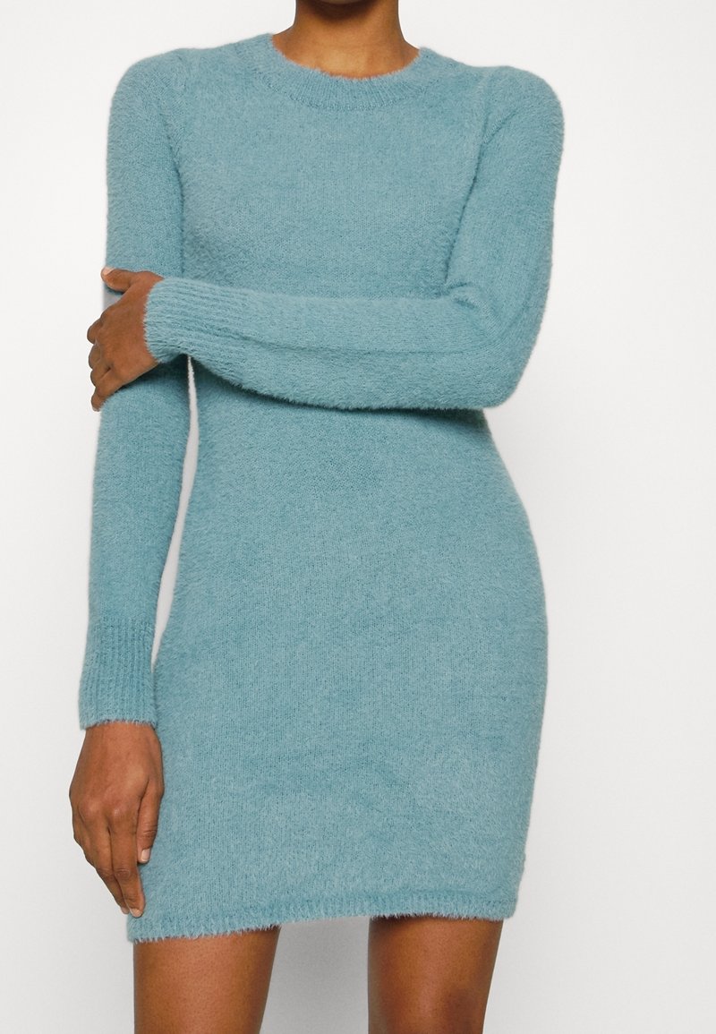 En figursydd långärmad klänning i mjukt, fuzzy himmelblått tyg med rund halsringning och ribbade manschetter, som slutar ovanför knäet.