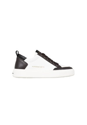 Baskets blanches avec des accents en cuir noir, bout rond, semelle en caoutchouc et logo doré "Alexander Smith" sur le côté. Dotées de lacets plats.