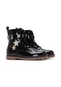 Botines de charol negro con un acabado brillante, que presentan dos apliques de estrellas en contraste, cierre de cordones en la parte delantera y detalle de correa con hebilla.