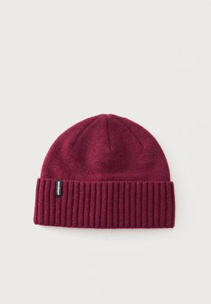 Dunkelrote gestrickte Beanie mit umgeschlagenem Rippenbund und einem kleinen schwarzen Patagonia-Logoetikett an der linken Seite.