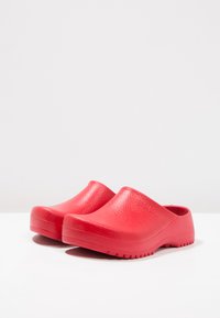 Rode rubberen klompen met een gestructureerd oppervlak, ronde neus en een ontwerp zonder achterkant; met een dikke zool met antisliptraction.