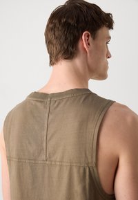 Uten ermer olivengrønn tanktop med rund hals, med en rett søm bak og myk, teksturert stoff.