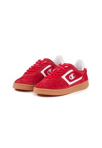 Sneakers in suede rosso con accenti bianchi, dotati di punta arrotondata, colletto imbottito e suola in gomma. I lacci brillanti completano il design.