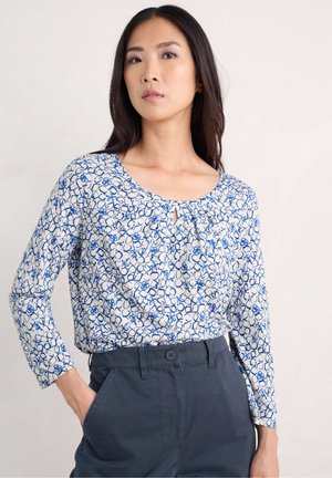 Lightweight, long-sleeve blouse with a blue and white circular pattern, featuring a keyhole detail at the neckline and soft texture.