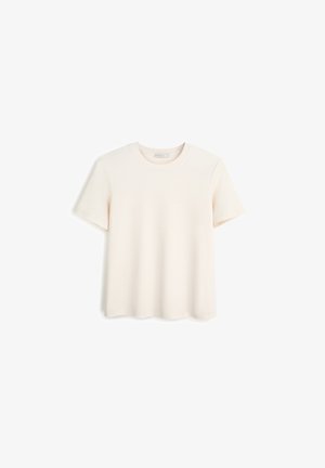 Koszulka z krótkim rękawem w jasnobeżowym kolorze, wykonana z bawełny, z okrągłym dekoltem, luźnym krojem i gładką fakturą. Brak widocznych wzorów lub akcentów.