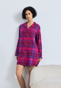 Flanellen nachtshirt in roze, paars en blauw ruitpatroon. Met lange mouwen, een kraag en knoopsluiting. Zachte textuur, knie-lange ontwerp.