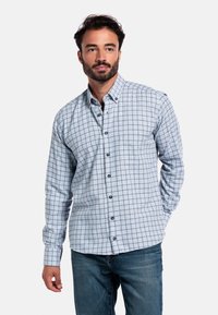 Lichtblauw overhemd met knoopjes en een ruitpatroon in marineblauw. Lange mouwen, afgeronde zoom en borstzak. Gecombineerd met donkere jeans.