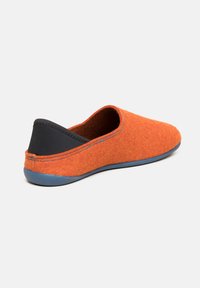 Orange filt slip-on sko med en rund form, tekstureret overflade og en sort stofhæleaccent. Har en blå gummisål.