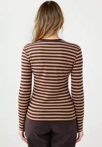 Długi rękaw top z poziomymi paskami w odcieniach brązu i jasnego beżu. Miękka tkanina z dopasowanym krojem i okrągłym dekoltem.