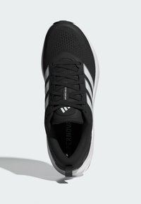 Black athletic shoe with a textured upper, featuring white stripes, a padded collar, and a logo on the tongue. White sole for added contrast.