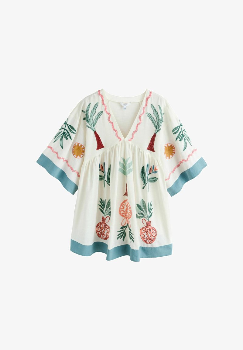 Blouse blanche ample avec broderies botaniques vertes, orange et rouges, bordure bleue aux manches et à l'ourlet, et col en V.