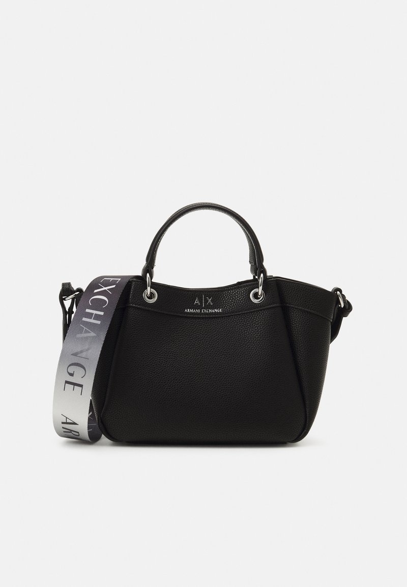 Sac à main en cuir noir texturé avec de petites poignées et une large bandoulière grise amovible avec le texte "Exchange" sur fond blanc.