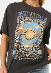 Sort t-shirt med farverig sol- og naturgrafik med teksten "Ripcurl". Løs pasform, korte ærmer, lavet af bomuldsstof. Design med tre farver.