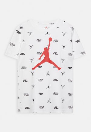 Biały T-shirt z krótkim rękawem z czerwonymi i czarnymi logo Jumpman oraz czarnym napisem "Jumpman" w wzory na całej tkaninie.