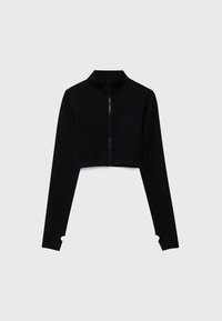 Veste courte noire à manches longues avec col haut et fermeture éclair à l'avant, présentée sur un fond gris clair uni.