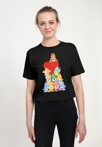 Zwart t-shirt met kleurrijke beerafbeeldingen met harten en bloemen, tegen een rode hartachtergrond, van katoen, in een relaxte pasvorm.
