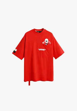 Camiseta de algodón roja con mangas cortas, que presenta un bolsillo y un gráfico impreso de un personaje. Texto "MWM" mostrado en la parte frontal.