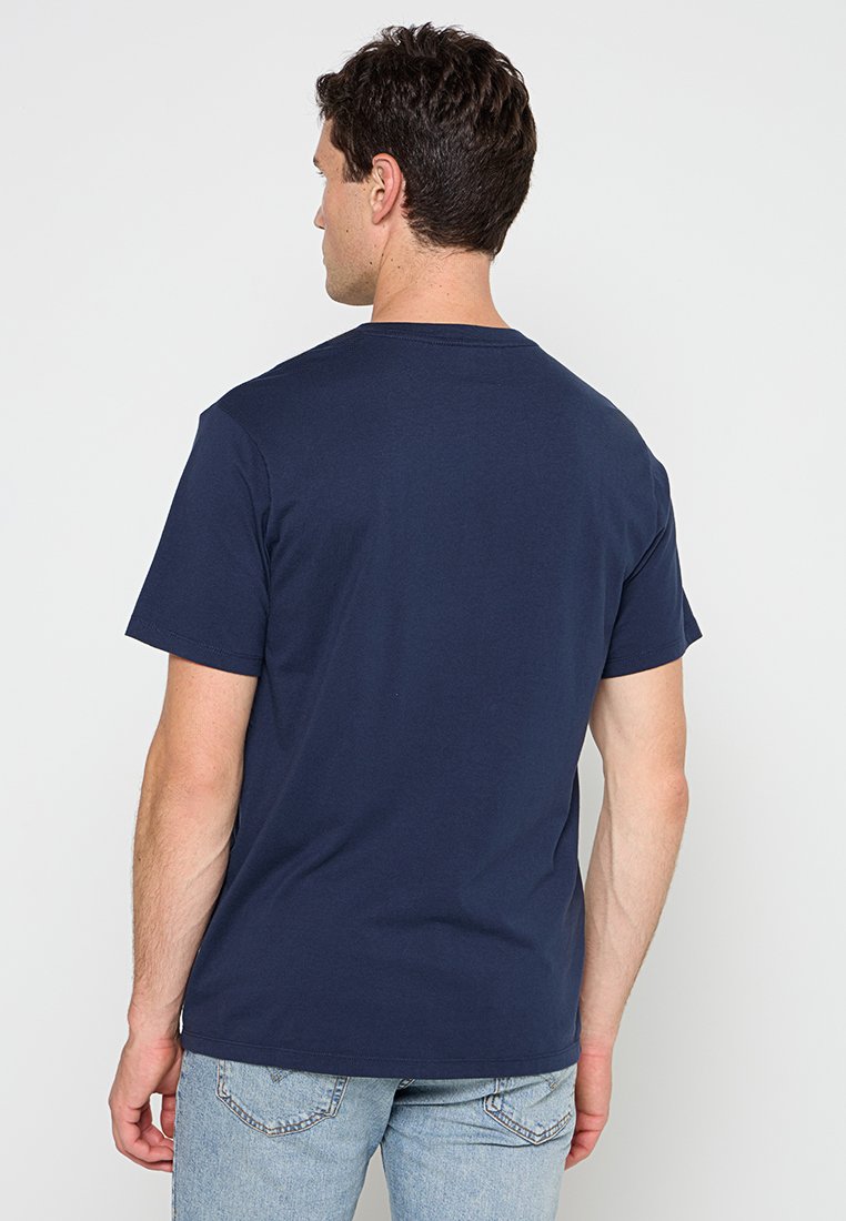 Camiseta de algodón azul marino con mangas cortas, un cuello redondo clásico y una textura suave, vista desde la parte de atrás.