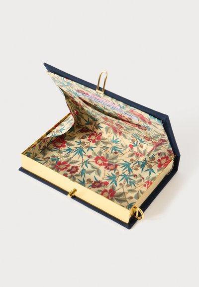 Aukso metalinė dėžutė su tamsiai mėlynu audinio kraštu ir gėlėmis raštuotu vidumi. Atvira konstrukcija, rodanti kruopščius detalių ir aparatūros sprendimus.