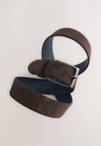 Ceinture en daim marron perforée avec une doublure intérieure lisse bleue et une boucle rectangulaire en métal argenté. Réglable avec plusieurs trous pour la taille.