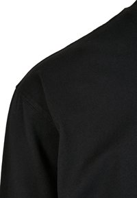 Crna pamučna majica s okruglim izrezom, kratkim rukavima i glatkom, teksturiranom tkaninom s čistim, minimalnim dizajnom.