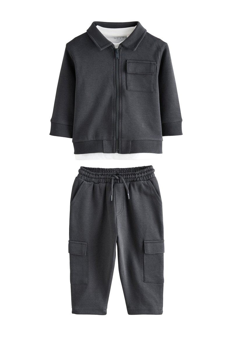Survêtement gris foncé en deux pièces comprenant une veste zippée avec col et poche poitrine, assortie d'un pantalon cargo à taille élastique avec poches latérales.