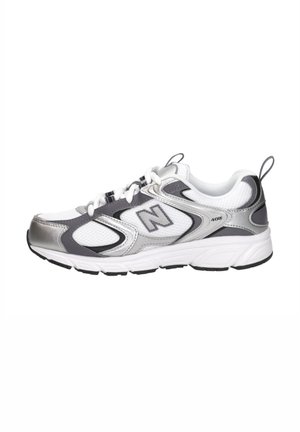 Chaussure de course New Balance 408 blanche et argentée avec des accents noirs, tige en mesh et fermeture à lacets, vue de côté extérieur.