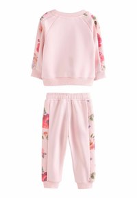 Ensemble sweatshirt et joggers rose ; le sweatshirt a des manches à motifs floraux et des poignets côtelés ; les joggers comportent des accents floraux sur les côtés. Matière douce.