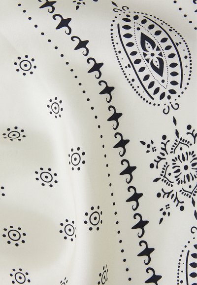 Kokvilnas bandana ar baltu fonu, kas rotāta ar sarežģītiem tumši zila paisley un apļa rakstiem, ar gludu tekstūru un vieglu sajūtu.