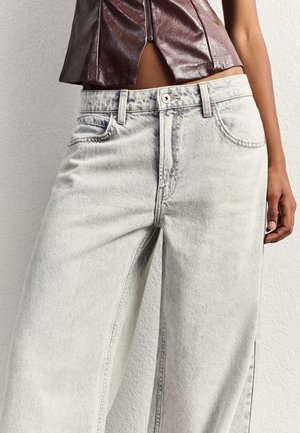 Graue weite Jeans aus Denim mit verblasstem Finish, ausgestattet mit Fronttaschen, einem Knopfverschluss und einer lockeren Passform.