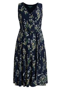 Marinblå blommig omlotklänning med V-ringning, ärmlös design och knytning i midjan. Tyget har en slät textur med vita och gröna blommönster.