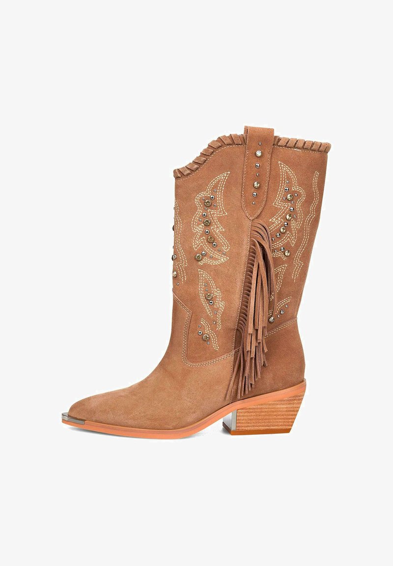 Botas de cowboy de ante marrón con detalles de flecos, tachuelas metálicas y costuras decorativas. Presentan una punta afilada y un tacón apilado.