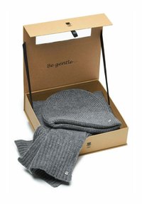 Gray knitted hat and scarf set, presented in a brown gift box, with "Be gentle..." printed inside. Box features decorative accents.