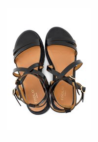 Zwarte leren sandalen met meerdere kruisschoenen, een tan kleurige inlegzool en een kleine hak. Voorzien van een enkelbandje met een gouden gesp.