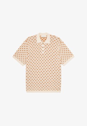 Strikket poloskjorte i krem med et gjentakende diamantmønster i brent oransje. Har krage og tre knapper ved halsen.
