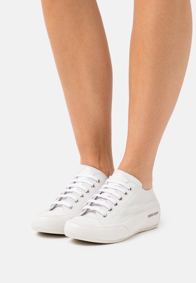 Sneakers bianchi con tomaia in tela, design con lacci e suola in gomma. Presentano occhiali argentati e un dettaglio laterale con marchio.