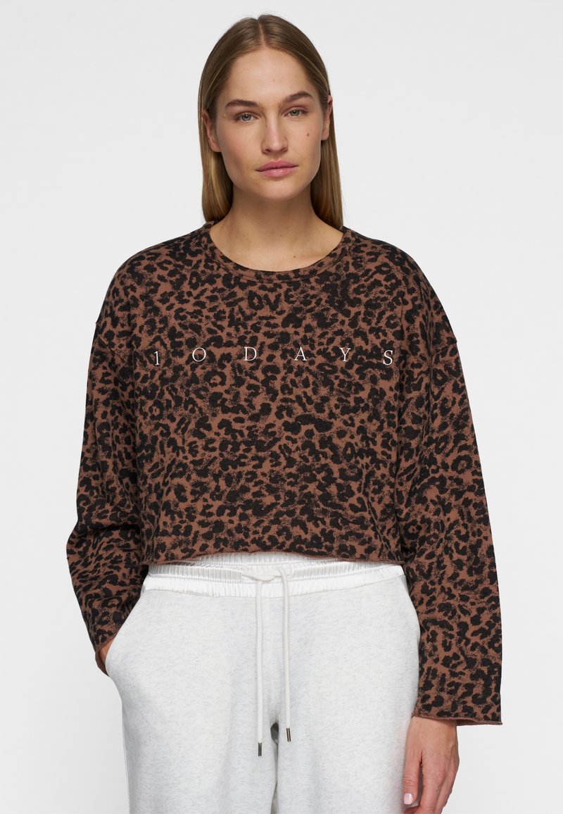Sweatshirt court en imprimé léopard marron et noir avec des manches longues et un col rond. "AUJOURD'HUI" imprimé en blanc sur le devant.