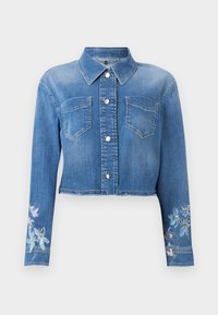 Κοντό μπουφάν από μπλε τζιν με ασημένια κουμπιά, δύο τσέπες στο στήθος, μυτερή γιακά και λουλουδάτα σχέδια στα μανίκια κοντά στις μανσέτες.