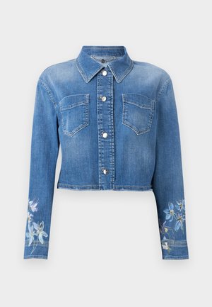 Κοντό μπουφάν από μπλε τζιν με ασημένια κουμπιά, δύο τσέπες στο στήθος, μυτερή γιακά και λουλουδάτα σχέδια στα μανίκια κοντά στις μανσέτες.