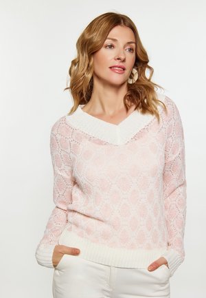 Maglione rosa chiaro lavorato a maglia con un motivo testurizzato e colletto a V bianco, dotato di maniche lunghe e polsini a coste.