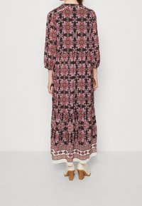 Robe maxi à imprimé floral sombre ; elle possède des manches trois-quarts, un col rond et une bordure à motif blanc en bas.