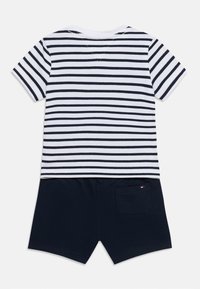 Ριγέ κοντομάνικη μπλούζα σε λευκό και ναυτικό μπλε, σετ με σορτς σε ναυτικό μπλε. Διαθέτει πίσω τσέπη. Μαλακό βαμβακερό υλικό, άνετη εφαρμογή.