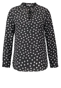 Blouse noire à manches longues avec motif à pois blanc circulaire et col en V court.