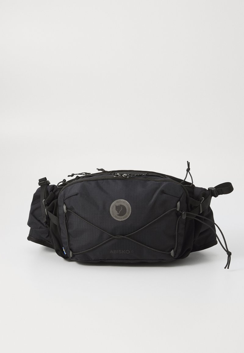 Black fabric waist bag with adjustable straps, zippered compartments, and a circular logo. Features a textured surface and elastic bungee cords.