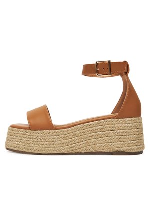 Brązowy sandał na koturnie ze skóry z paskiem wokół kostki, z podeszwą z juty, odkrytymi palcami i gładkim wykończeniem.