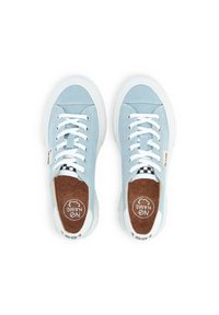 Scarpe da ginnastica in tela azzurro chiaro con lacci bianchi, suole in gomma bianche e soletta in sughero con un accento a scacchi bianco e nero.